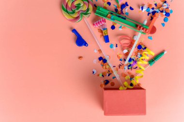 Parti konfeti, flamalar ve Borazanlar turuncu zemin üzerine kırmızı hediye kutusu. Kutlama kavramı