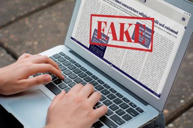 Bilgisayarda dijital sahte haberler okuyan genç bir kadının yakın çekimi. Propaganda ve yanlış bilgilendirme çevrimiçi. Medya ve dijital kavram. Tüm ekran grafikleri bizim tarafımızdan yapıldı.