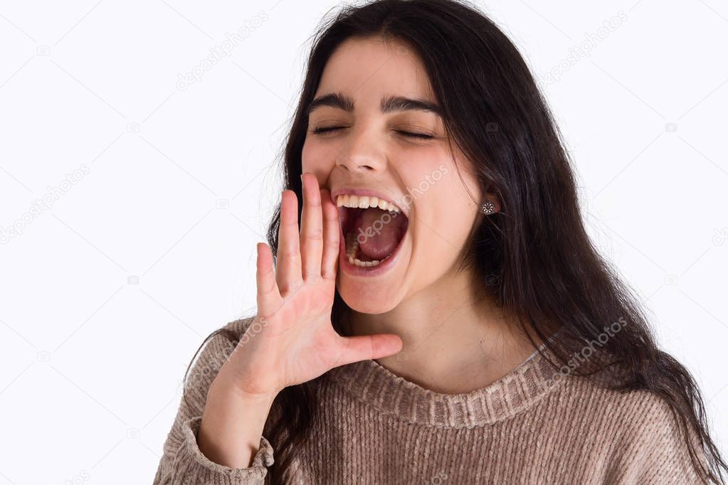 Portrait of beautiful young woman shouting and screaming, studio shoot.