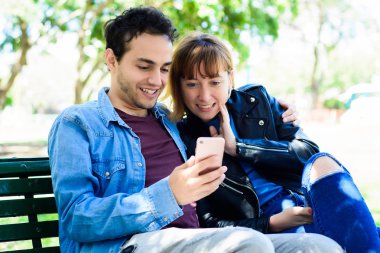 Genç çift olan uygulama smartphone açık havada üzerinde kullanarak eğlenceli.