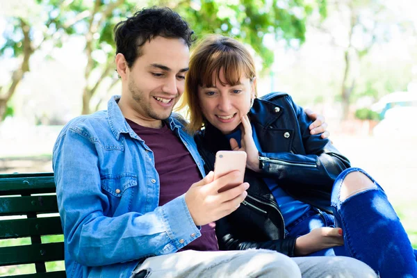 Genç çift olan uygulama smartphone açık havada üzerinde kullanarak eğlenceli.