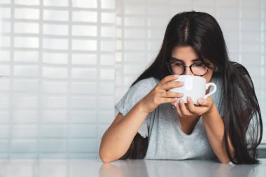 Genç ve güzel kadın evde mutfakta kahve içme