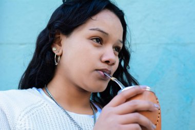 Geleneksel Arjantin yerba mate çay içme genç latin kadın portresi. Güney Amerika popüler içecek. Açık havada