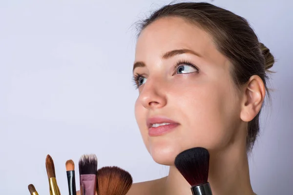 Mujer joven con cepillo de maquillaje —  Fotos de Stock