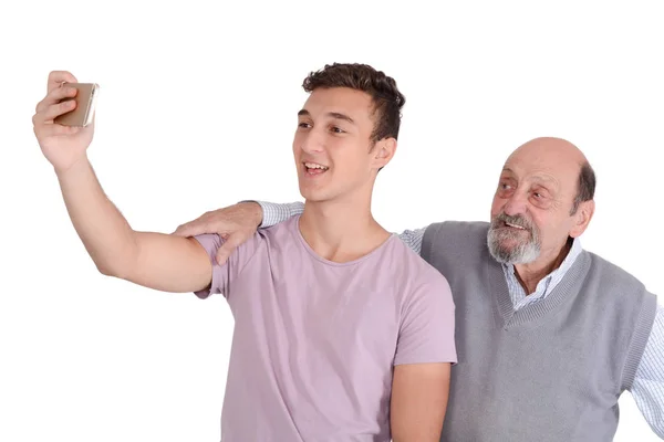 Abuelo y su nieto adolescente tomando una selfie . — Foto de Stock