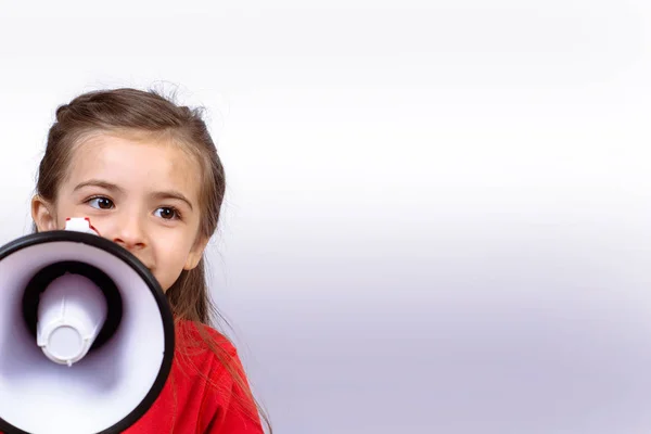 Kis lány sikoltozik a egy megafon. — Stock Fotó