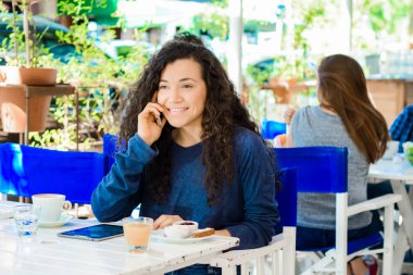 Genç kadın cep telefonunda kahve dükkanında söz