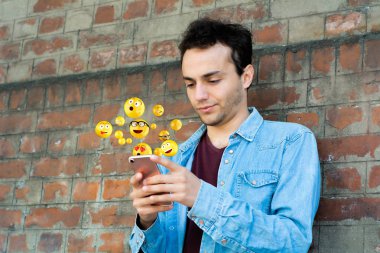 Emojis gönderme smartphone kullanan adam