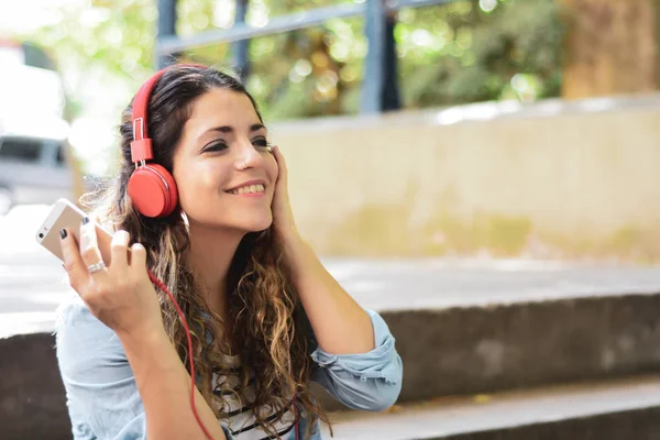 Jovem mulher ouvindo música com fones de ouvido. — Fotografia de Stock