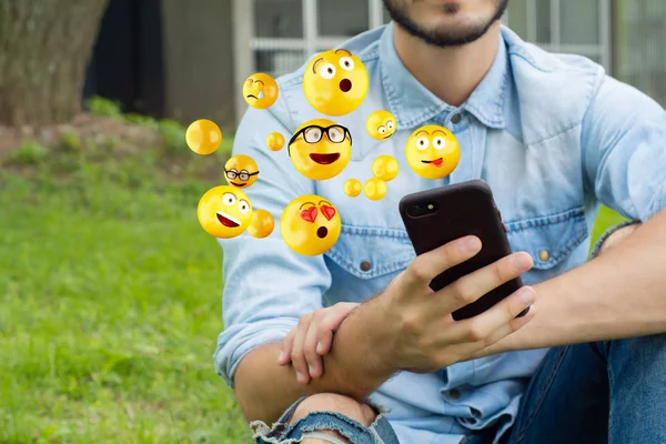 Homem usando smartphone enviando emojis — Fotografia de Stock