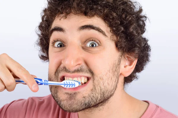 Grappige jongeman wassen zijn tanden. — Stockfoto