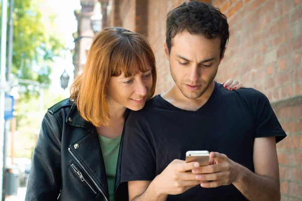 Young couple using application on smartphone — Stock Photo, Image