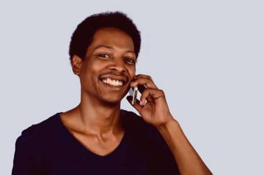 Afro Amerikan adam telefonda konuşuyor.