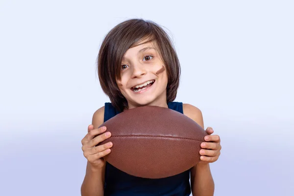 Mały chłopiec z piłką futbol amerykański. — Zdjęcie stockowe