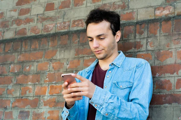 Fiatal ember gépelés a telefonját. — Stock Fotó