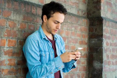 Genç adam telefonunu yazarak.