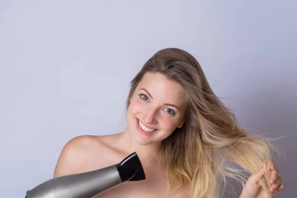 Vrouw haar haren met droger drogen — Stockfoto