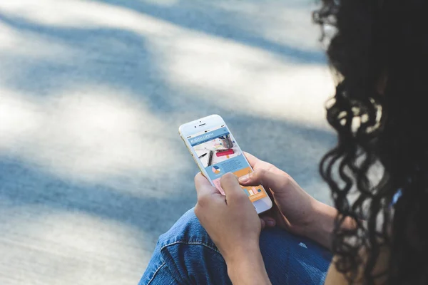 Mãos de mulher segurando smartphone mostrando estatísticas sobre compan — Fotografia de Stock