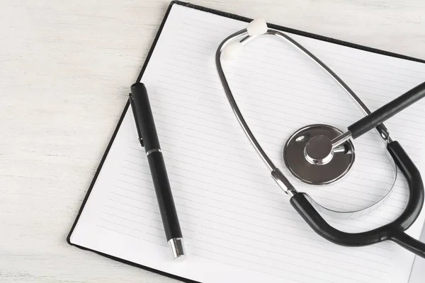 Halaman buku catatan kosong di meja dokter dengan stetoskop — Stok Foto