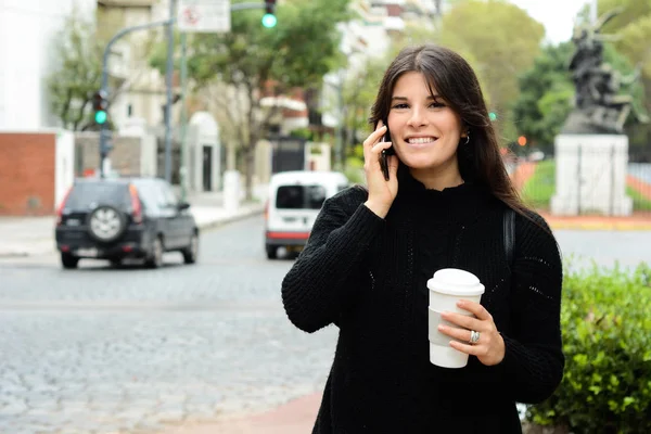Mujer latina joven con su teléfono móvil y una taza de café —  Fotos de Stock