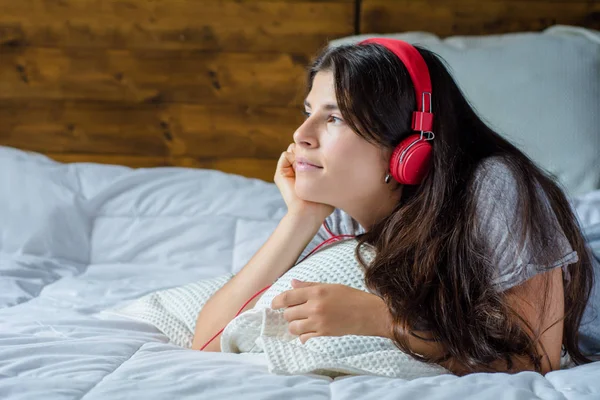 Giovane donna godendo la musica sul letto . — Foto Stock