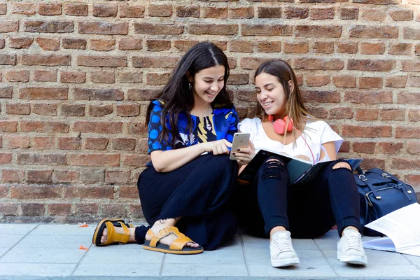 Два студента смеются и учатся по телефону . — стоковое фото