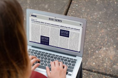 Genç kadın haber dizüstü bilgisayarda okuma closeup