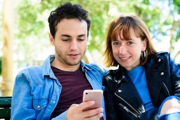 Young couple using application on smartphone — Stock Photo, Image
