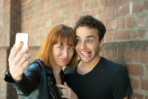 Pareja joven tomando selfie con teléfono móvil al aire libre . — Foto de Stock