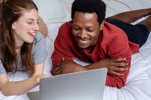 Evde bir yatakta laptop kullanarak genç çift. — Stok fotoğraf