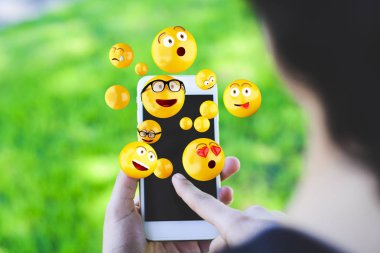 Emojis gönderme smartphone kullanan kadın.