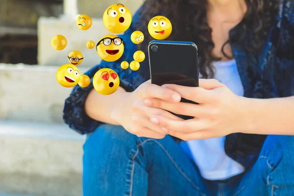 Nahaufnahme einer Frau, die per Smartphone Emojis verschickt. Gesellschaftliches Konzept. — Stockbild Frau mit Smartphone verschickt Emojis. — Stockfoto