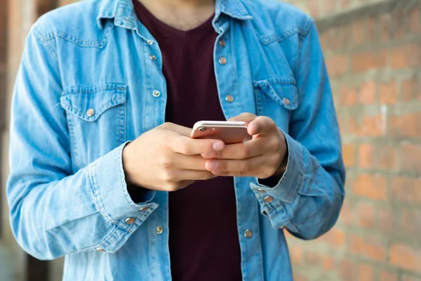 Young man typing on his phone. — Stock Photo, Image