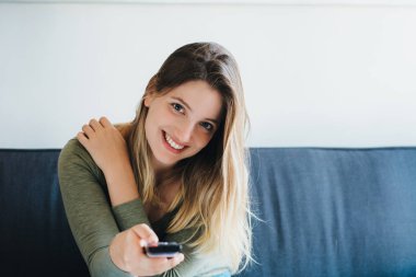 Kanepede oturan ve tv izlerken güzel kadın