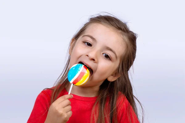 Klein meisje eet een lolly. — Stockfoto