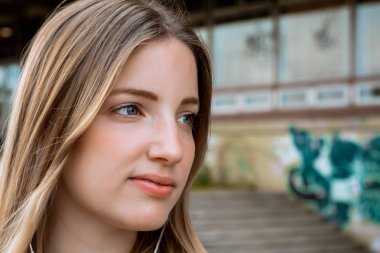 Kulaklık ile müzik dinleyen genç sarışın kadın