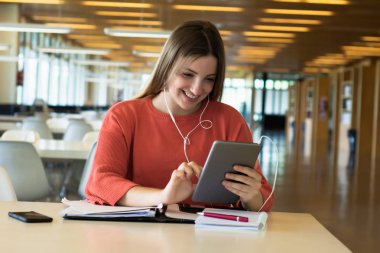 Kütüphanede okuyan genç kız öğrenci.