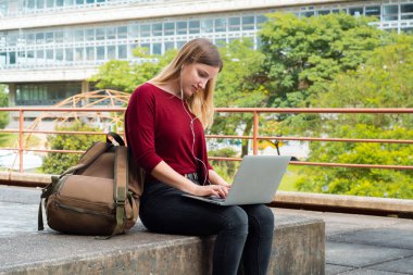 Açık havada Laptop kullanan genç öğrenci. 