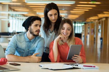 Üniversite kütüphanesinde dijital tablet kullanan üniversite öğrencileri. 