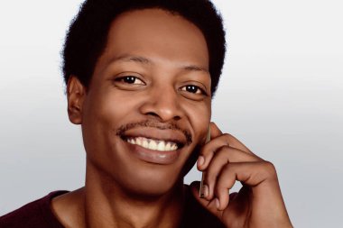 Afro Amerikan adam telefonda konuşuyor.