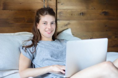 Genç kadın yatakta onu laptop kullanma