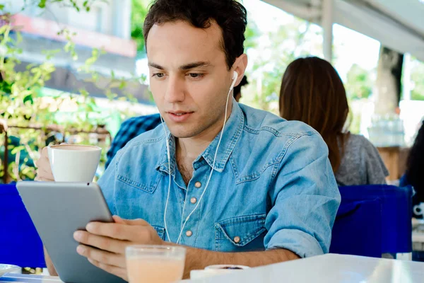 Young man with tablet in coffee shop. — Stock Photo, Image