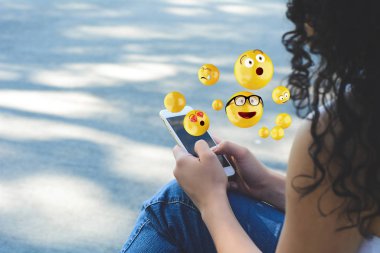 Emojis gönderme smartphone kullanan kadın.