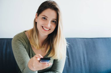 Kanepede oturan ve tv izlerken güzel kadın