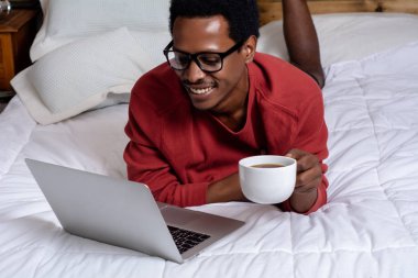 Yatakta onun laptop kullanan genç adam