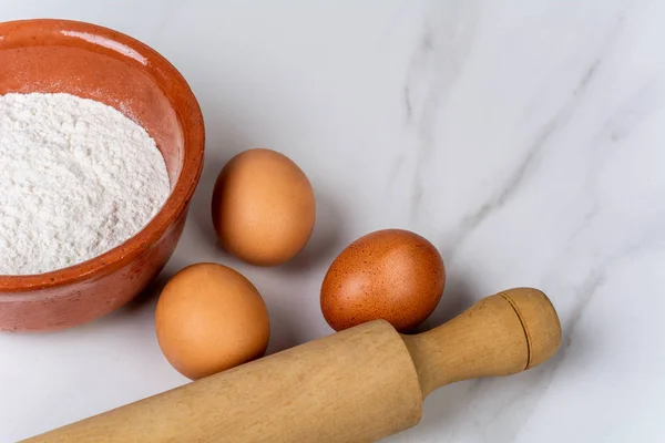 Rolling pin, cup of flour and eggs. — Stock Photo, Image