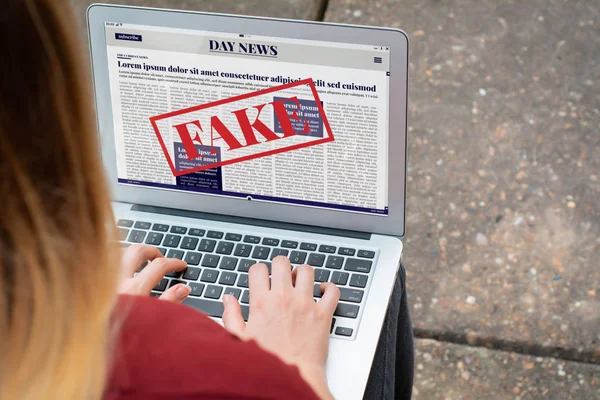 노트북에서 디지털 가짜 뉴스를 읽는 젊은 여성 — 스톡 사진