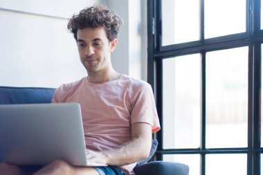 Dizüstü bilgisayar ile kanepede rahatlatıcı adam