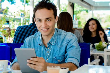 Kafede tablet ile genç adam.
