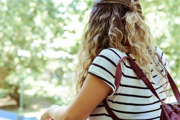 Young woman from behind looking at park.